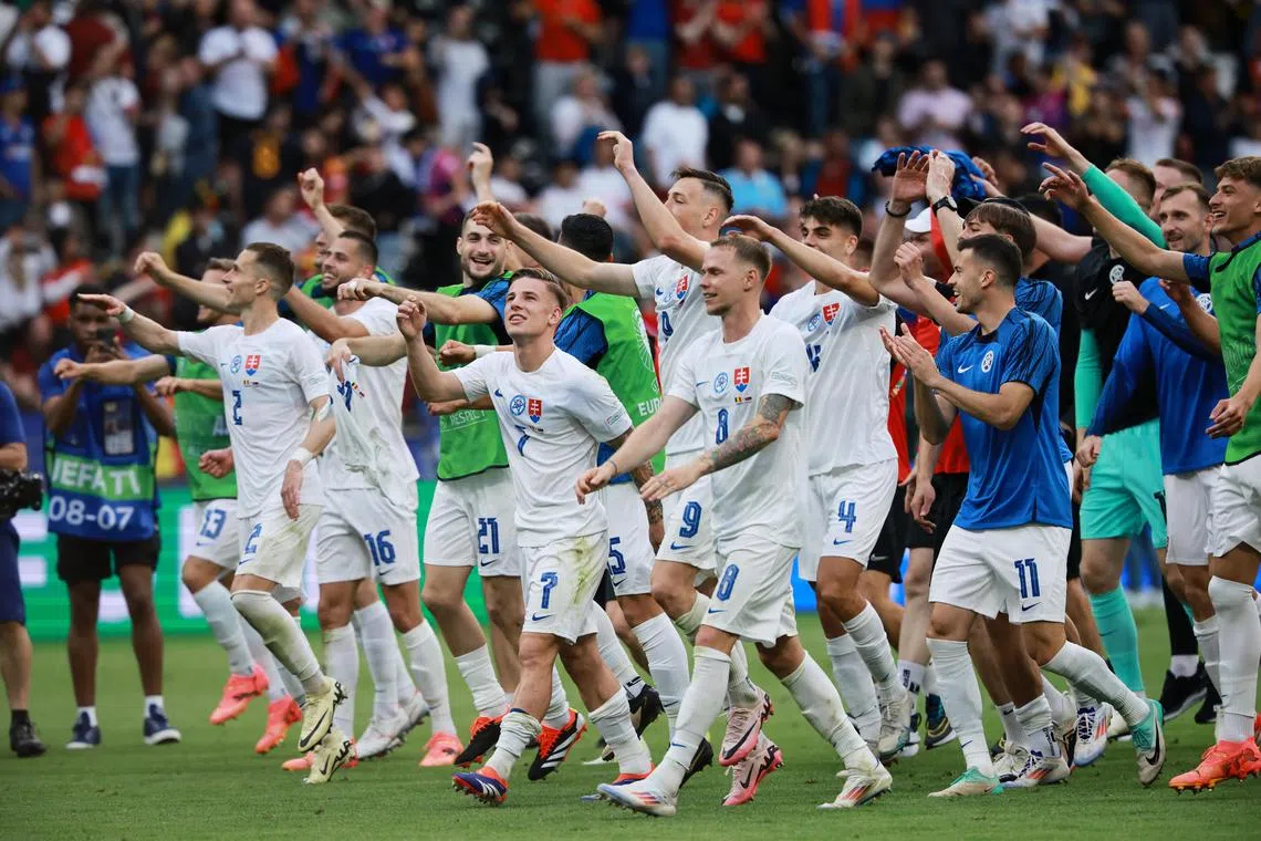Slovakia players celebrate with fans after winning their Euro 2024 opener against Belgium.