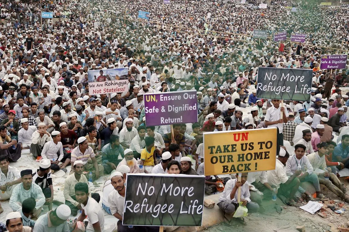 Rohingya refugees hold placards while attending a Ramadan Solidarity Iftar to have an Iftar meal with United Nations Secretary-General Antonio Guterres and Muhammad Yunus, Chief Adviser of Bangladesh Interim Government, at the Rohingya refugee camp in Cox's Bazar, Bangladesh, March 14, 2025. REUTERS/Mohammad Ponir Hossain