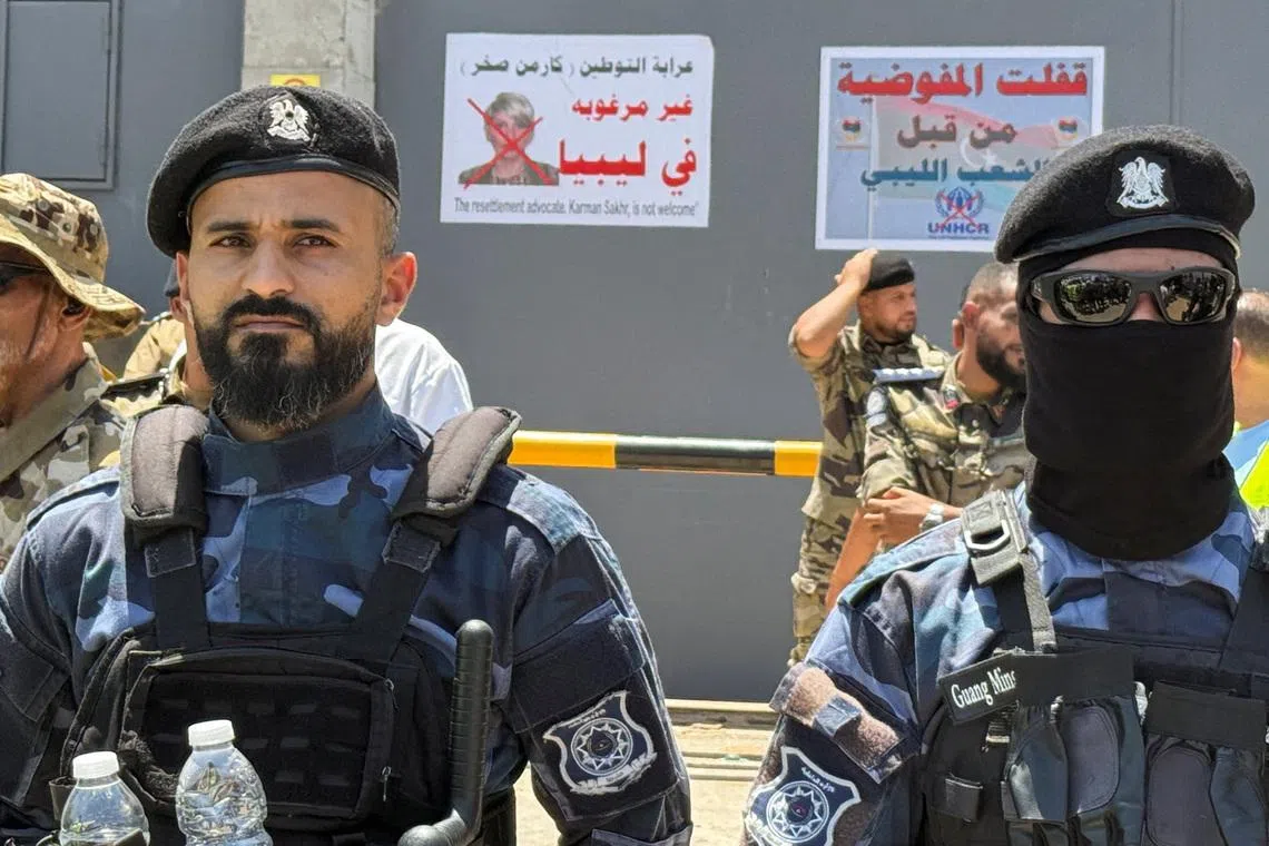 Security personnel stand guard as protesters gather outside the headquarters of the United Nations High Commissioner for Refugees (UNHCR), demanding the organisation leave the country and calling for an end to migrant settlement and the deportation of migrants and refugees, in Tripoli, Libya, June 4, 2026. Picture taken with a mobile phone. REUTERS/Ayman al-Sahili