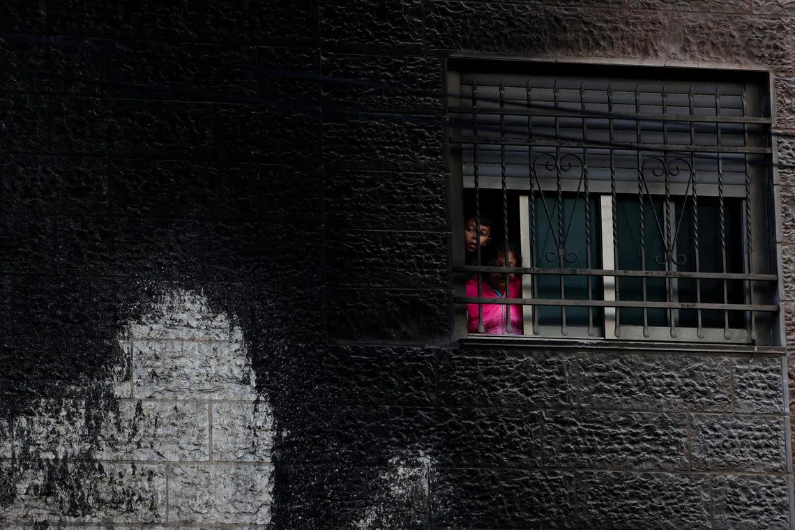 FILE PHOTO: Palestinians look through a window after an Israeli settlers attack in Al-Bireh city, in the Israeli-occupied West Bank, November 4, 2024. REUTERS/Mohammed Torokman/File Photo