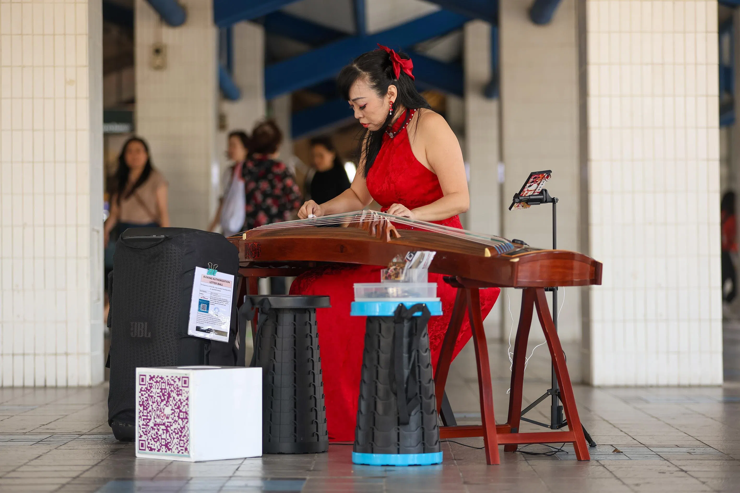 Ms Michelle Chua playing the guzheng at Tampines MRT interchange on Jan 30.