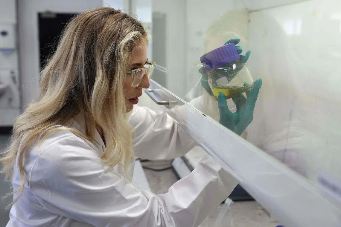 Chemical analyst Kate Griffiths dissolving an electronic component in chemicals to remove the gold at the Royal Mint in Llantrisant, Wales on June 30.