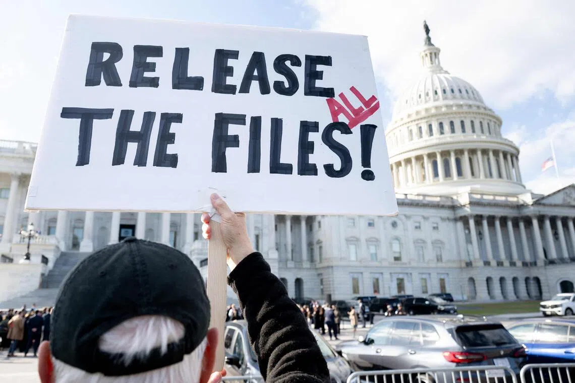 A protester holds a sign related to the release of the Jeffrey Epstein case files outside the US Capitol in Washington, DC, Nov 12, 2025. PHOTO: AFP
