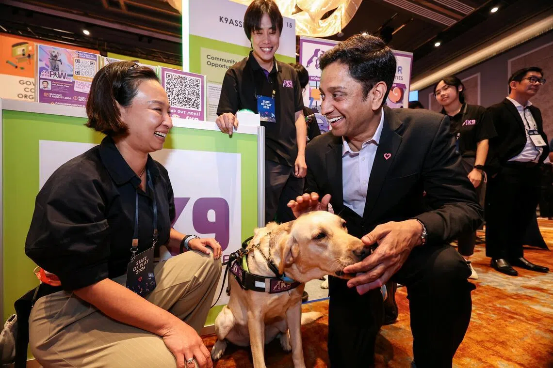 *EMBARGO UNTIL 3PM* Minister of State for Culture, Community and Youth and Manpower Dinesh Vasu Dash (right) petting an assistance dog while interacting with Ms Cassandra Chiu (left), 47, executive director of K9Assistance, while touring the State of Play exhibits at the City of Good Forum on March 31, 2026. ST PHOTO: BRIAN TEO