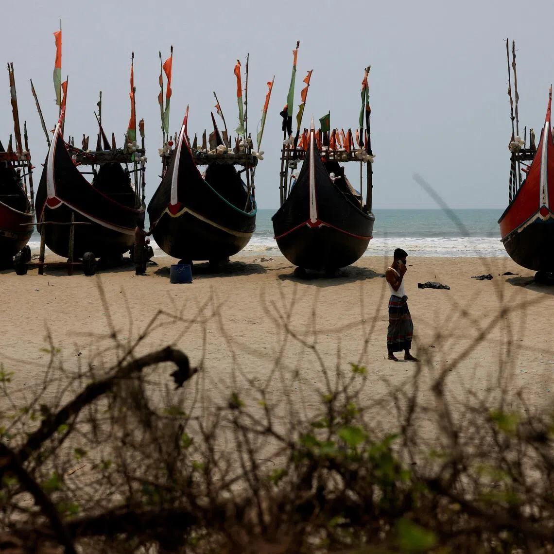 Faisal, 24, a human trafficker, speaks on a mobile phone at a beach near a Rohingya refugee camp, after a boat carrying Rohingya refugees and Bangladeshi nationals capsized in the Andaman Sea, Cox’s Bazar, Bangladesh, April 17, 2026. REUTERS/Mohammad Ponir Hossain     TPX IMAGES OF THE DAY