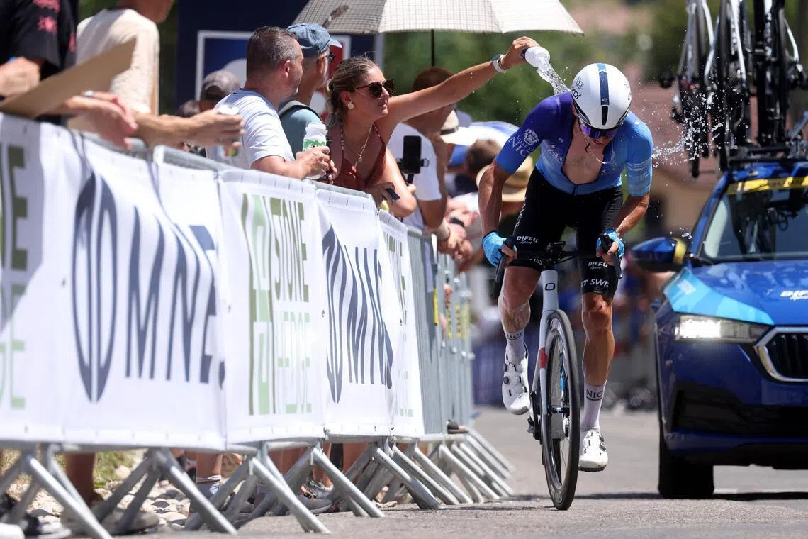 A spectator pouring water on a rider during the men’s elite road race of the French Cycling Championships on June 28.