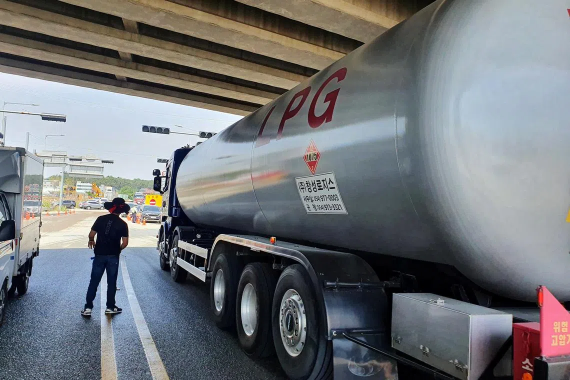 A member of the Cargo Truckers Solidarity union stands next to a LPG lorry in Ulsan, South Korea, June 10, 2022. 