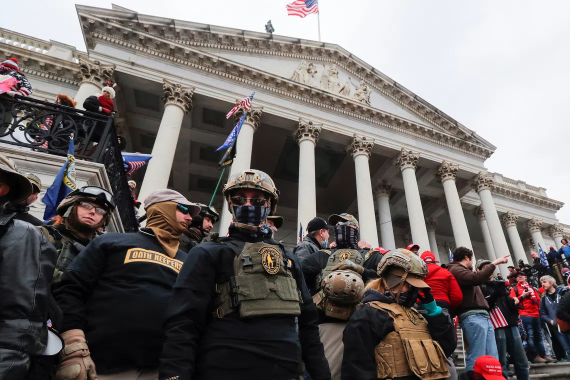 Emergency personnel and people gathered in front of a large, columned building.