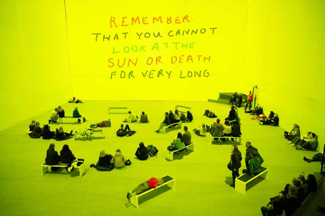 TOPSHOT - Visitors attend the 'David Hockney: Bigger & Closer (not smaller & further away)’ immersive exhibition in Aviva Studios, Manchester, north-west England on December 20, 2024. David Hockney's immersive show opened to the public in London last year and offers a hypnotic, multi-sensory journey through the artist's decades-long career, from sun-drenched California swimming pools to the Normandy countryside. (Photo by Oli SCARFF / AFP) / RESTRICTED TO EDITORIAL USE - MANDATORY MENTION OF THE ARTIST UPON PUBLICATION - TO ILLUSTRATE THE EVENT AS SPECIFIED IN THE CAPTION