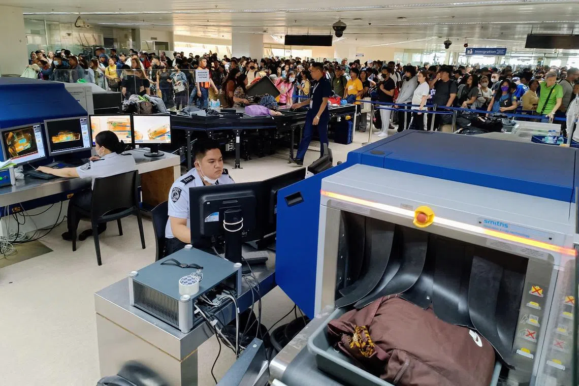 Hundred queue for security check at Manila's international airport. 