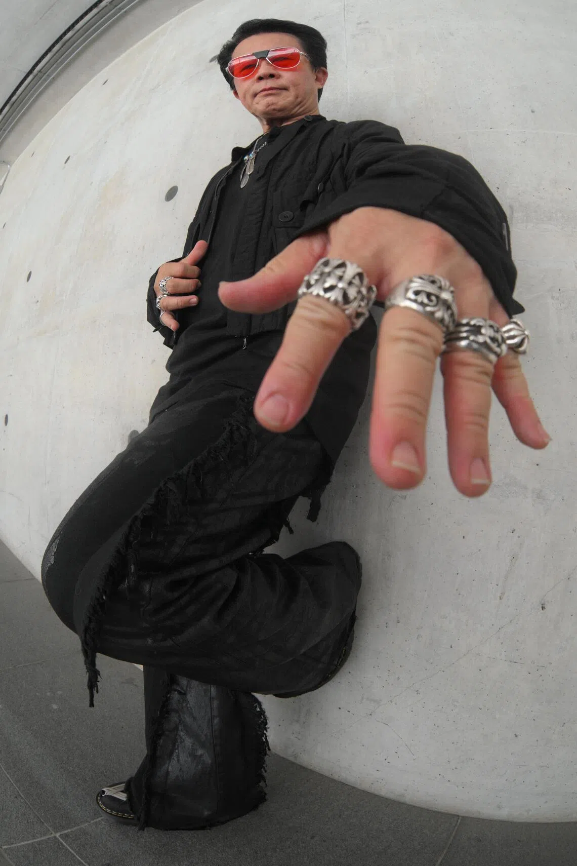 Mr Roger Tan accessorises with chunky silver rings and tinted sunglasses.