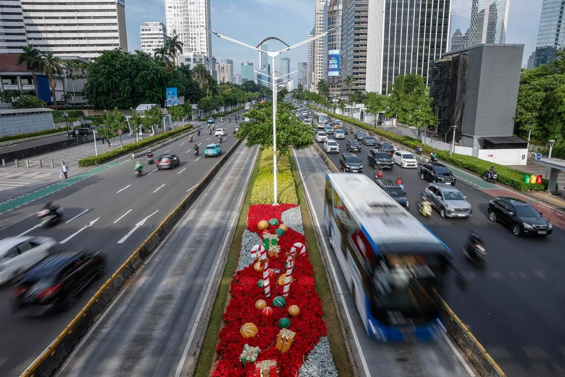 Vehicles pass a Christmas decoration on a busy street in Jakarta, Indonesia, on Dec 22, 2025.