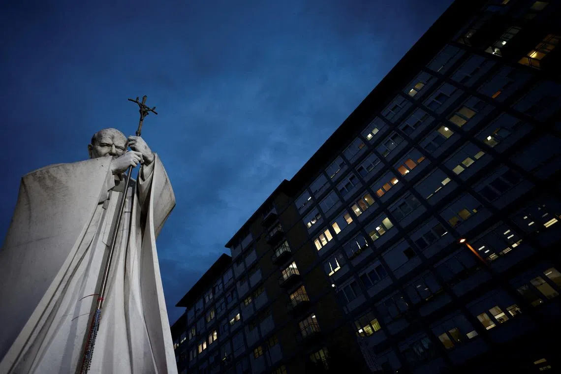 General view of the statue of late Pope John Paul II and Gemelli Hospital, where Pope Francis is admitted for ongoing pneumonia treatment, in Rome, Italy, March 10, 2025.