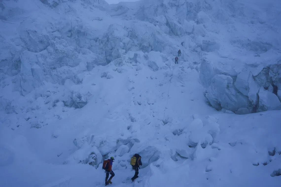 Members of an expedition team climb through the Khumbu Icefall during their rotation trip from Everest Base Camp to Camp 1 in the Solukhumbu district, also known as the Everest region.