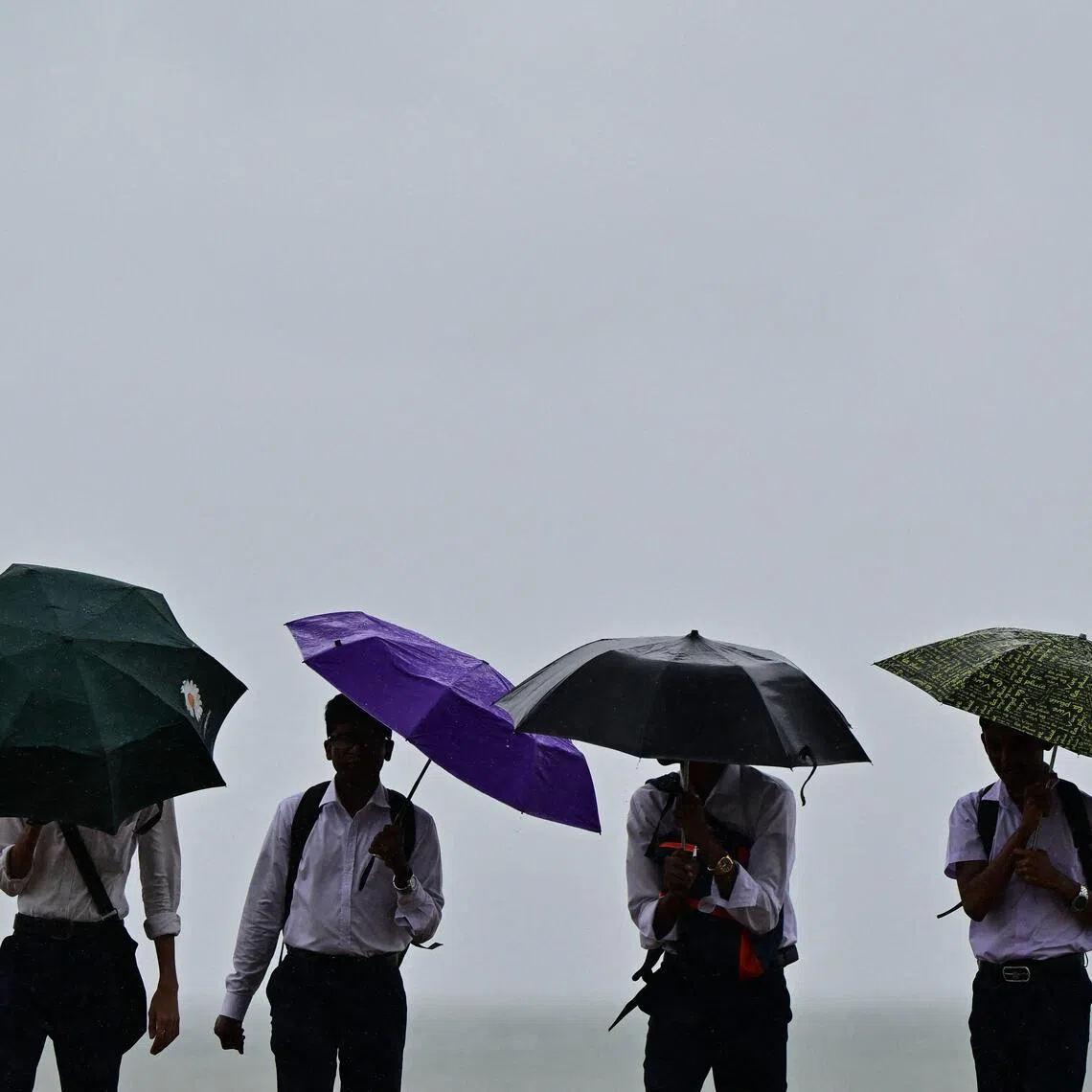 People carry umbrellas along a street, amid rainfall in Colombo on Nov 27.