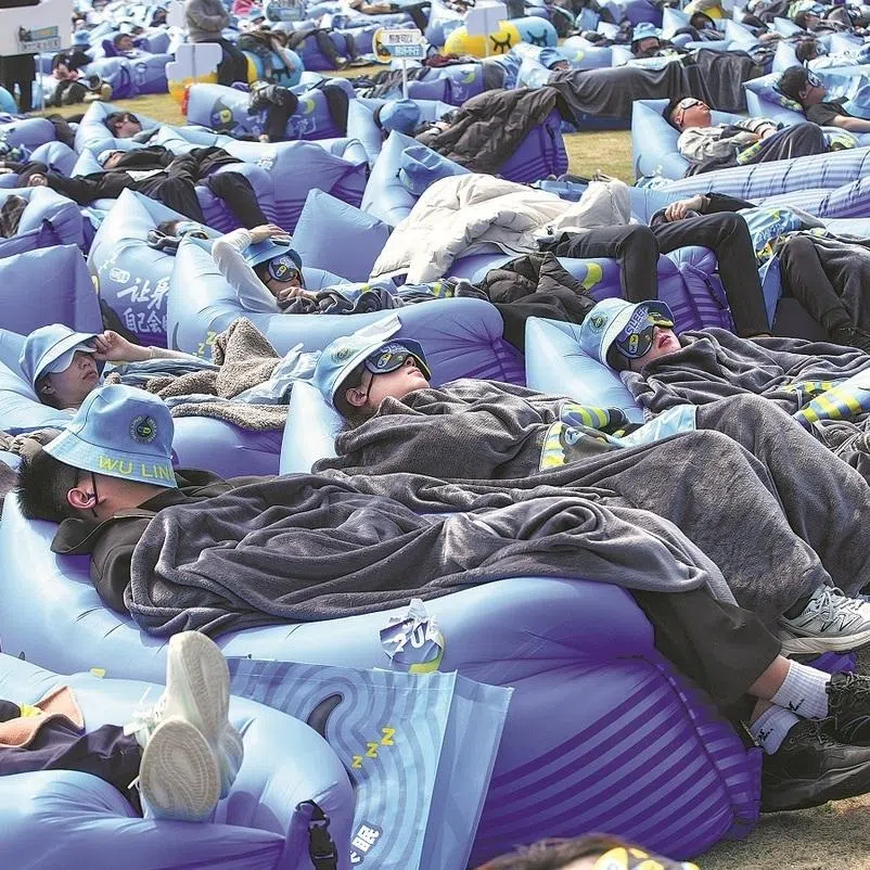 Sleep competition contestants rest on a lawn in Huzhou, Zhejiang province, on March 21.