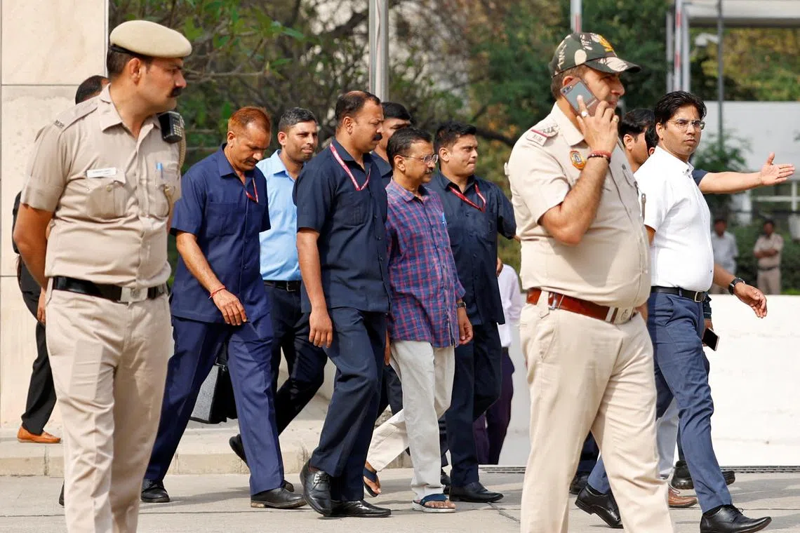 Police officers escort Chief Minister of Delhi and Aam Aadmi Party (AAP) Arvind Kejriwal as he leaves the court after a hearing in New Delhi, India on March 24.