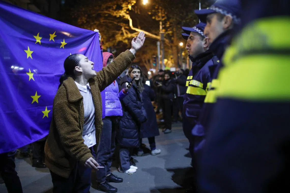 Georgians with an EU flag protesting in front of the offices of the ruling Georgian Dream party, in Tbilisi, on Nov 28.