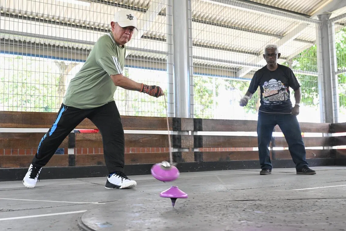 Ко Най Тиам бросает газовую или деревянную волчок в мяч Нурула Хаята во время игры на стадионе Kolam Ayer Gasing & Games Court 5 января.