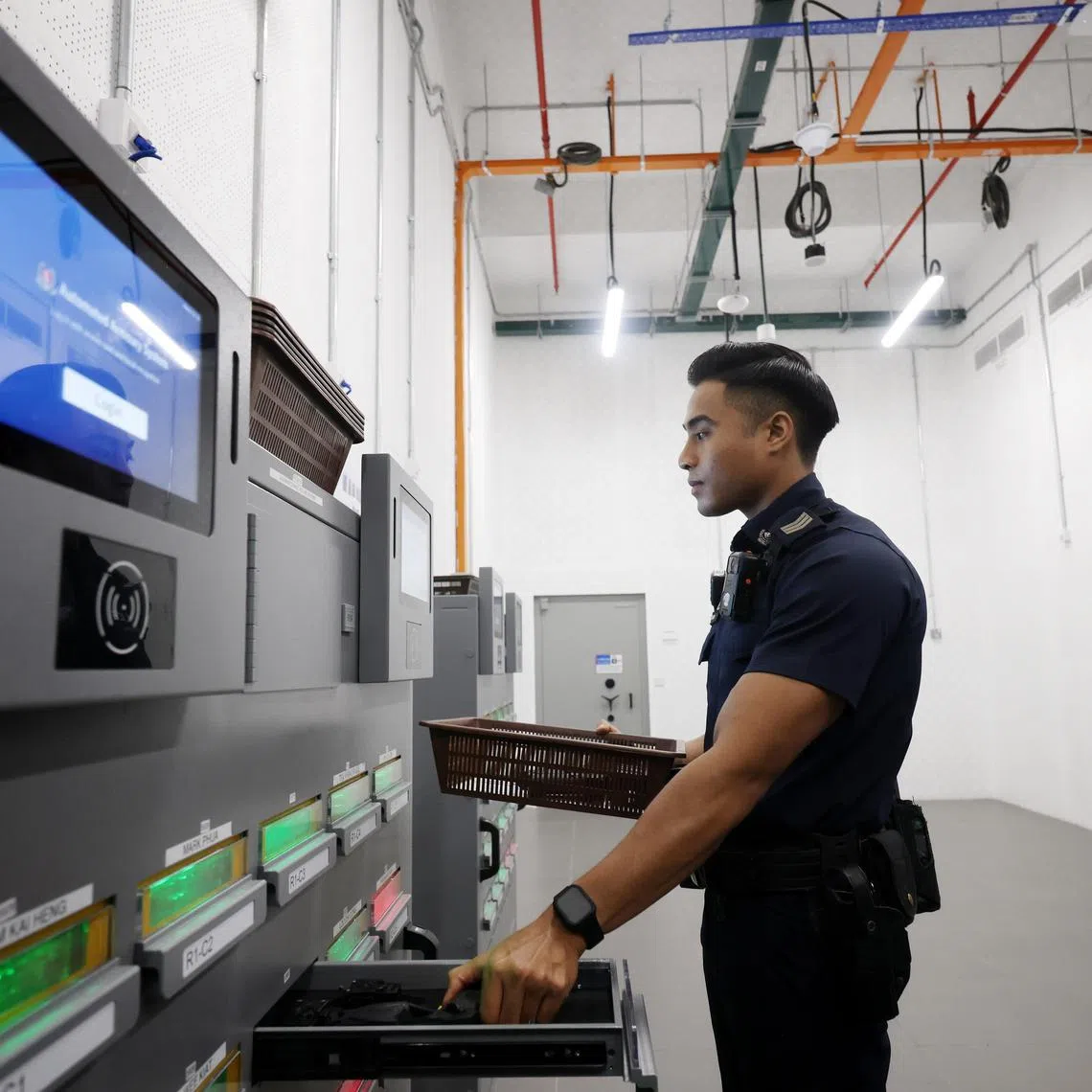SGT Farhan Shah demonstrates the withdrawal of arms through the automated armoury system (AAS) at Woodleigh Neighbourhood Police Centre on May 21, 2025. 