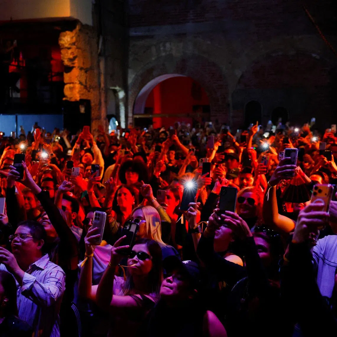 People dance and use their cell phones in Mexico on Dec 14, 2025. 