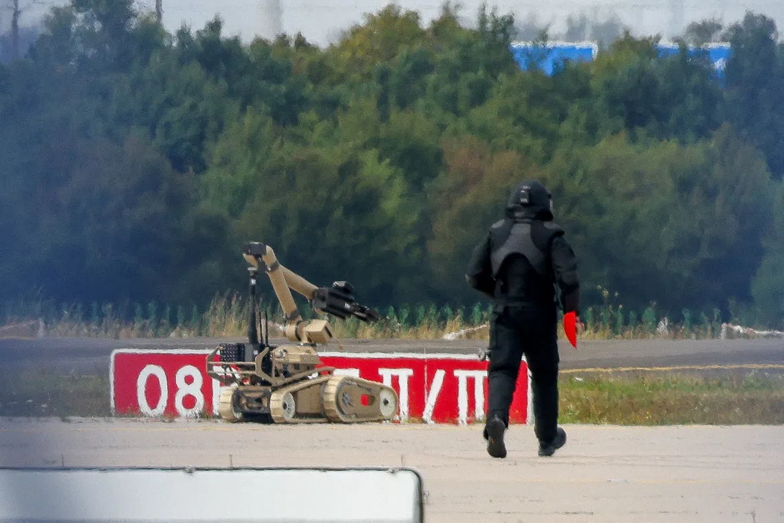 FILE PHOTO: A police officer in protective clothing walks next to an explosive-disarming robot (EOD) at Leipzig/Halle Airport in Schkeuditz, Germany, August 5, 2026. REUTERS/Axel Schmidt