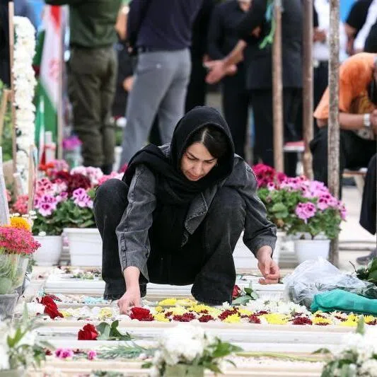 An Iranian woman adorning the grave of a loved one killed during the US-Israeli war against the Islamic republic in southern Tehran on April 23, 2026.