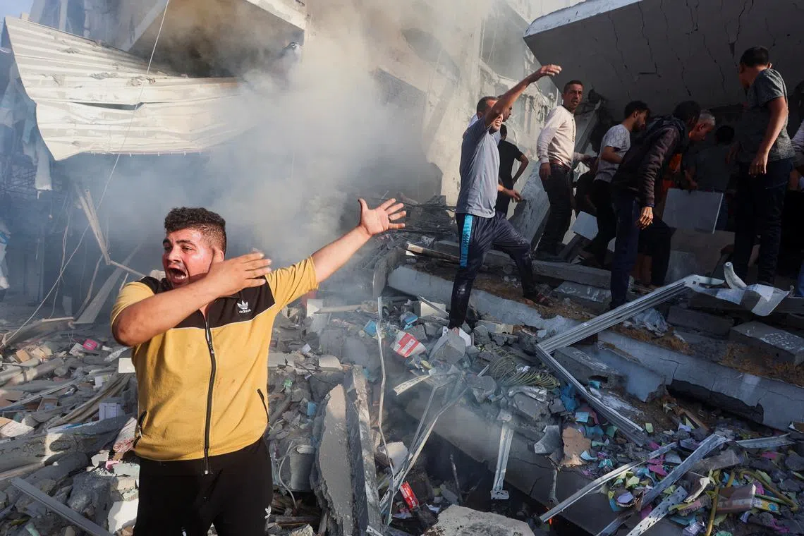 Palestinians at the site of Israeli strikes on a residential building in Khan Younis in the southern Gaza Strip, on Nov 7, 2023.