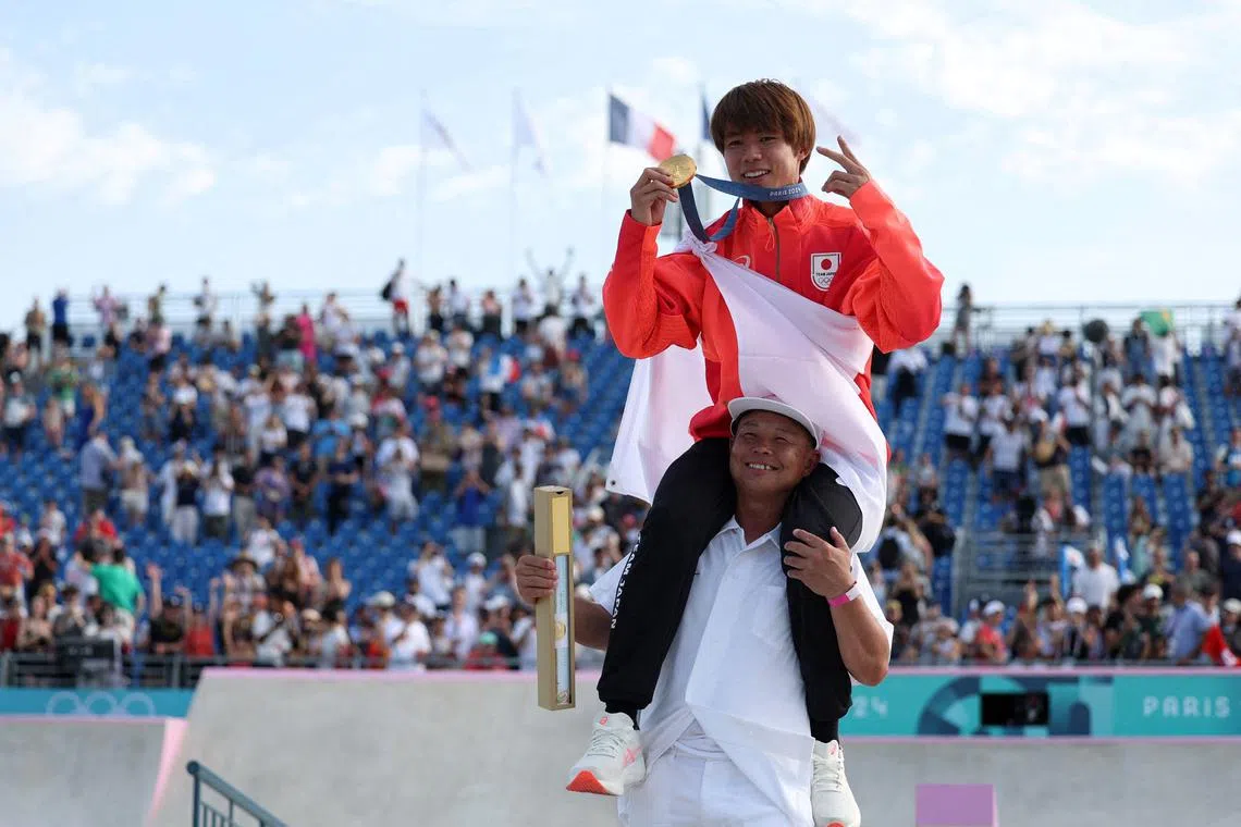 FILE PHOTO: Paris 2024 Olympics - Skateboarding - Men's Street Victory Ceremony - La Concorde 3, Paris, France - July 29, 2024. Gold medallist Yuto Horigome of Japan poses with his medal as he celebrates on the shoulders of his coach. REUTERS/Pilar Olivares/File Photo
