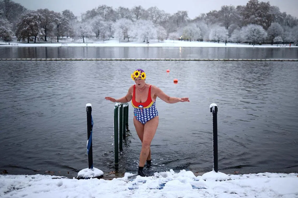A swimmer dips her feet in Serpentine lake, as cold weather continues, in London, Britain, Dec 12, 2022.