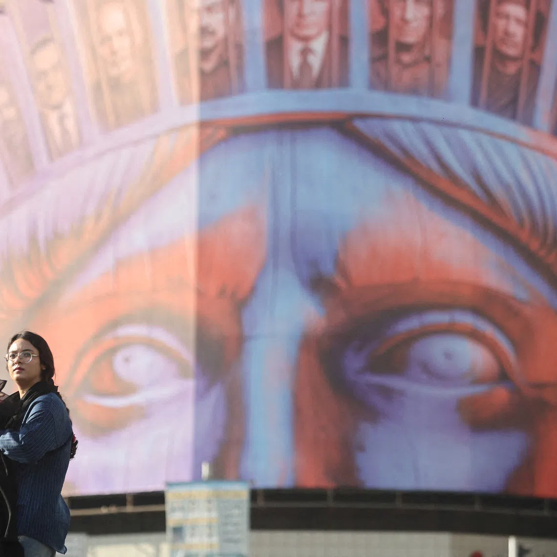FILE PHOTO: An Iranian woman walks past an anti-U.S. billboard on a street in Tehran, Iran, November 5, 2025. Majid Asgaripour/WANA (West Asia News Agency) via REUTERS /File Photo