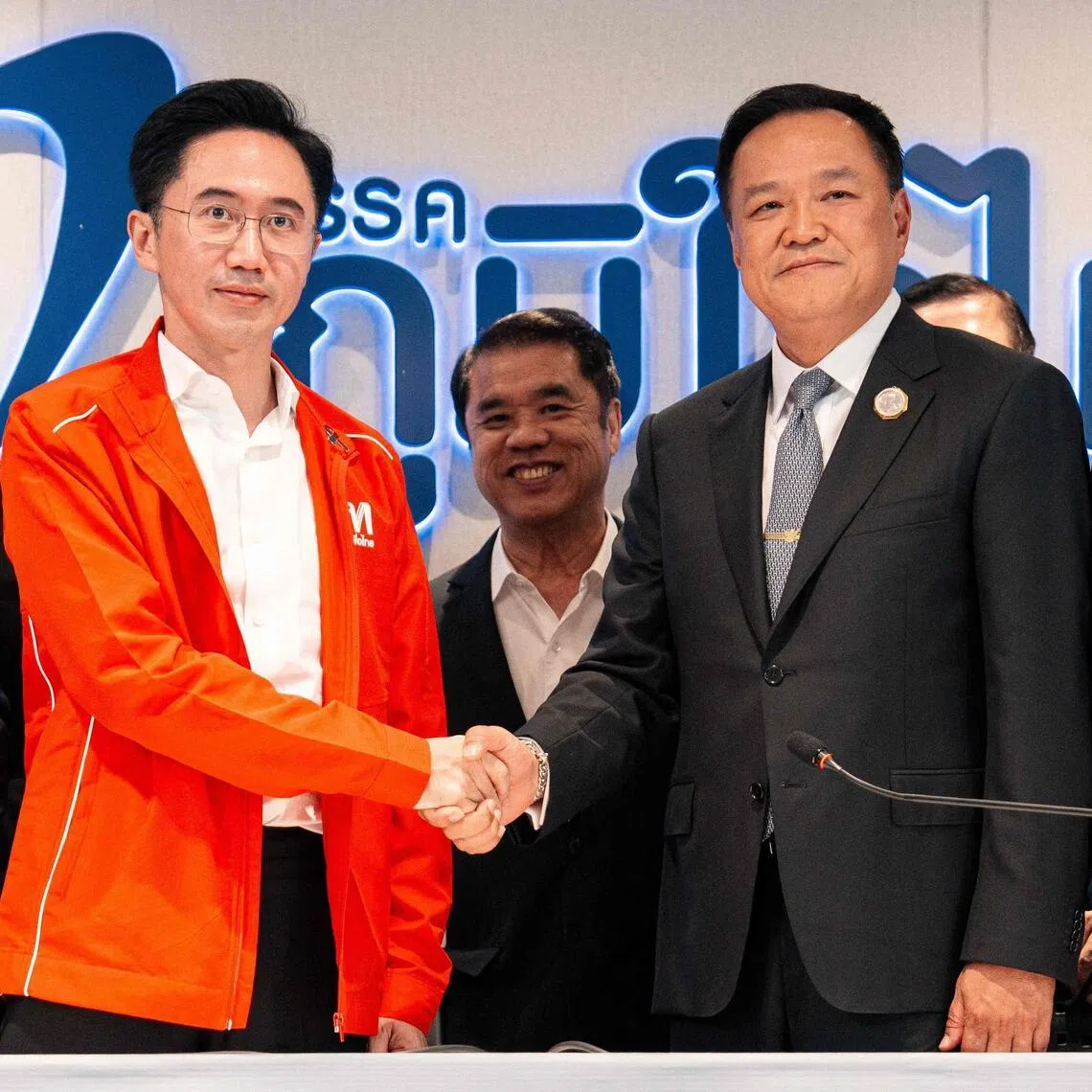 Thailand's caretaker Prime Minister Anutin Charnvirakul (centre R), leader of the Bhumjaithai party, shakes hands with the Pheu Thai Party's prime ministerial candidate Yodchanan Wongsawat (centre L) during a meeting at the Bhumjaithai headquarters in Bangkok on February 13, 2026. Thailand's caretaker Prime Minister Anutin Charnvirakul said February 13 that his Bhumjaithai party, which won the election at the weekend, agreed to form a coalition with jailed Thai ex-premier Thaksin Shinawatra's party. (Photo by Arnun Chonmahatrakool / THAI NEWS PIX / AFP)