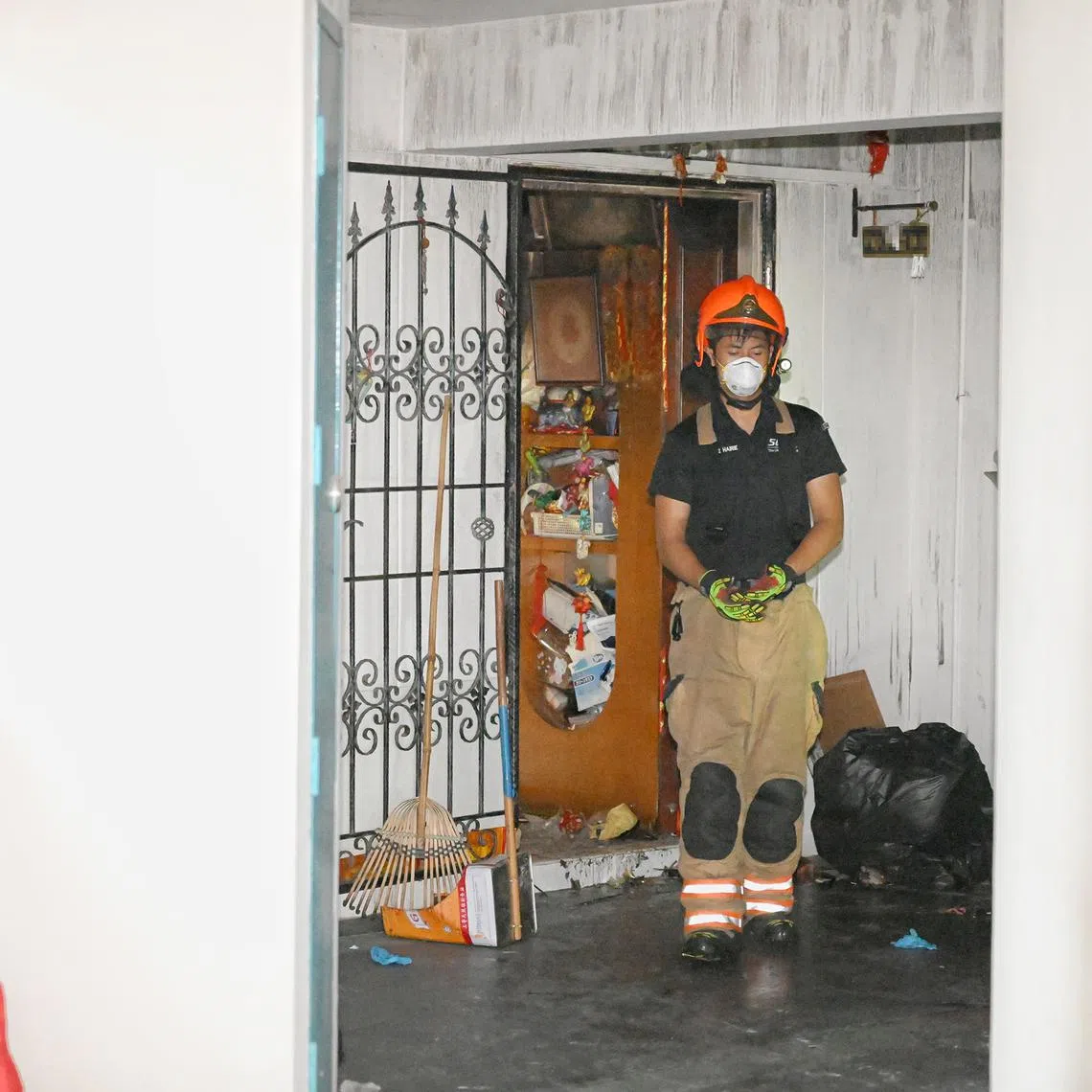 A firefighter at a flat in Block 971 Hougang Street 91 on Jan 10, a day after a fire broke out at the unit.
