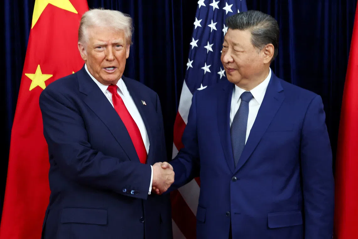 US President Donald Trump (left) shaking hands with Chinese President Xi Jinping as they hold a bilateral meeting at on the sidelines of the APEC summit, in Busan on Oct 30.