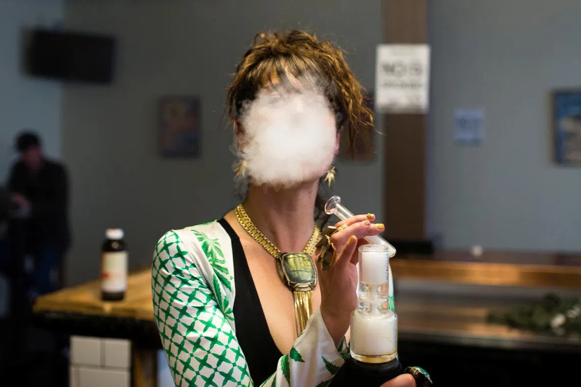 FILE PHOTO: A woman uses a full spectrum oil vaporizer at the Magnolia cannabis vape lounge in Oakland, California, U.S. April 20, 2018. . REUTERS/Elijah Nouvelage/File Photo