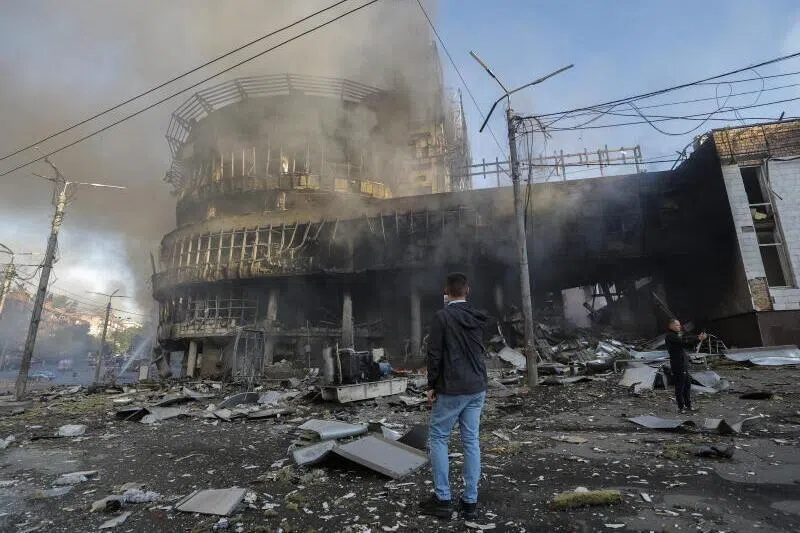 Local residents standing among debris at the site of a Russian strike on a shopping center in Kyiv, Ukraine, on May 24.