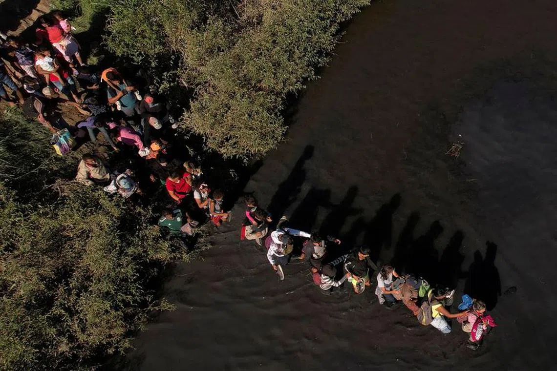 Migrants, who were stranded a day earlier near Villa Ahumada, and who are seeking asylum in the United States, cross the Rio Bravo river, as seen from Ciudad Juarez , Mexico September 30, 2023. REUTERS/Jose Luis Gonzalez