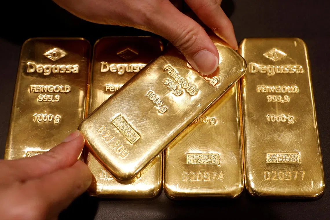 An employee shows gold bullions at a shop in Singapore.