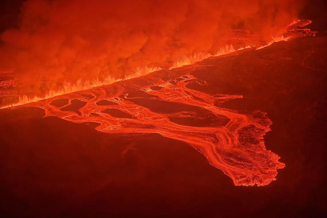 TOPSHOT - This handout picture released by the Icelandic Coast Guard on February 8, 2024 shows billowing smoke and flowing lava pouring out of a new fissure during a new volcanic eruption on the outskirts of the evacuated town of Grindavik, western Iceland. A volcanic eruption started on the Reykjanes peninsula in southwestern Iceland on Thursday, the third to hit the area since December, authorities said. (Photo by HANDOUT / Icelandic Coast Guard / AFP) / RESTRICTED TO EDITORIAL USE - MANDATORY CREDIT "AFP PHOTO /HANDOUT/ICELANDIC COAST GUARD " - NO MARKETING - NO ADVERTISING CAMPAIGNS - DISTRIBUTED AS A SERVICE TO CLIENTS
