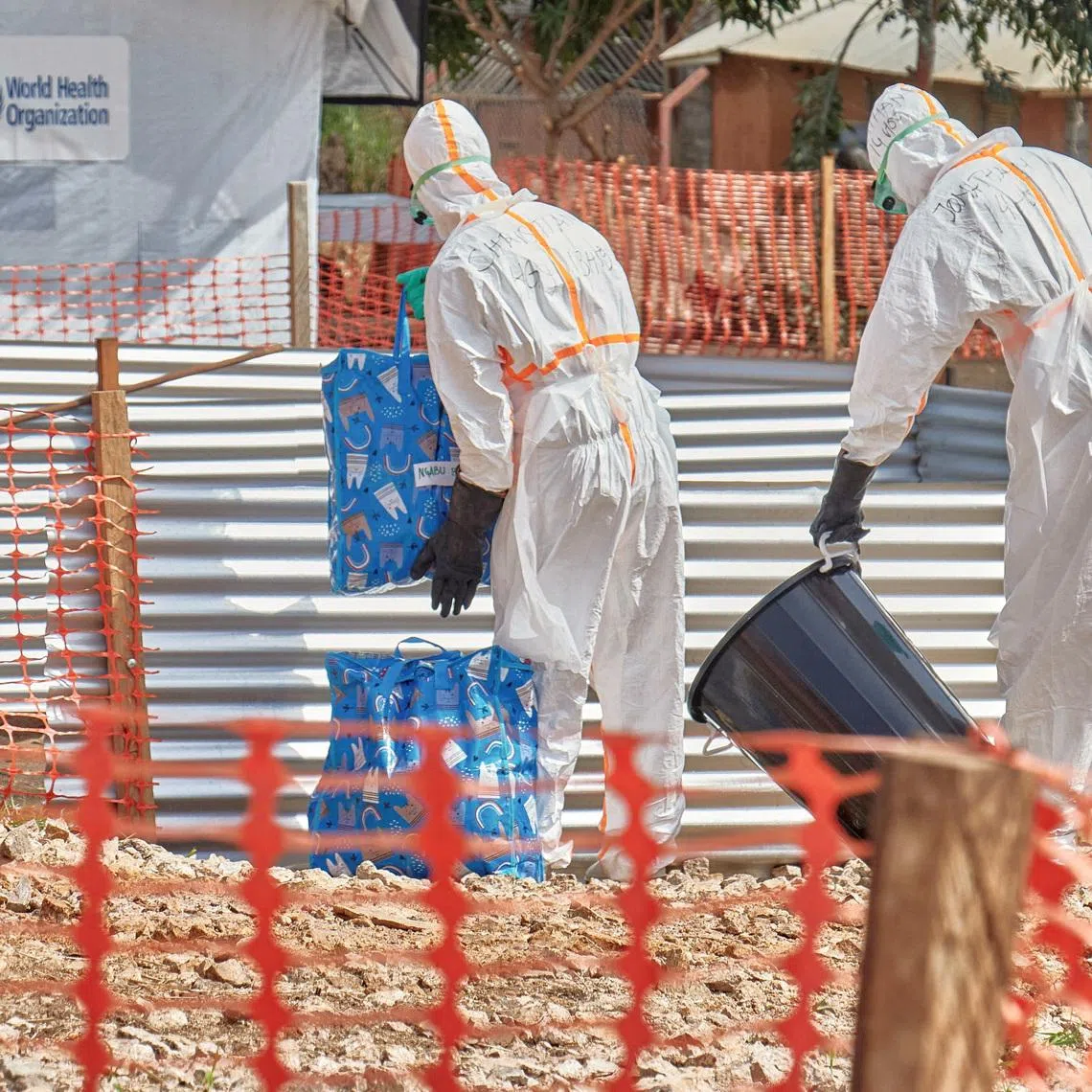 Congolese medical workers dressed in personal protective equipment (PPE) handle bags at the Centre Medical Evangelique (CME) within the secured Ebola response zone, as aid agencies intensify efforts to contain the Ebola outbreak involving the Bundibugyo strain, in Hoho commune of Bunia town, Ituri province, Democratic Republic of Congo, June 9, 2026. REUTERS/Gradel Muyisa Mumbere