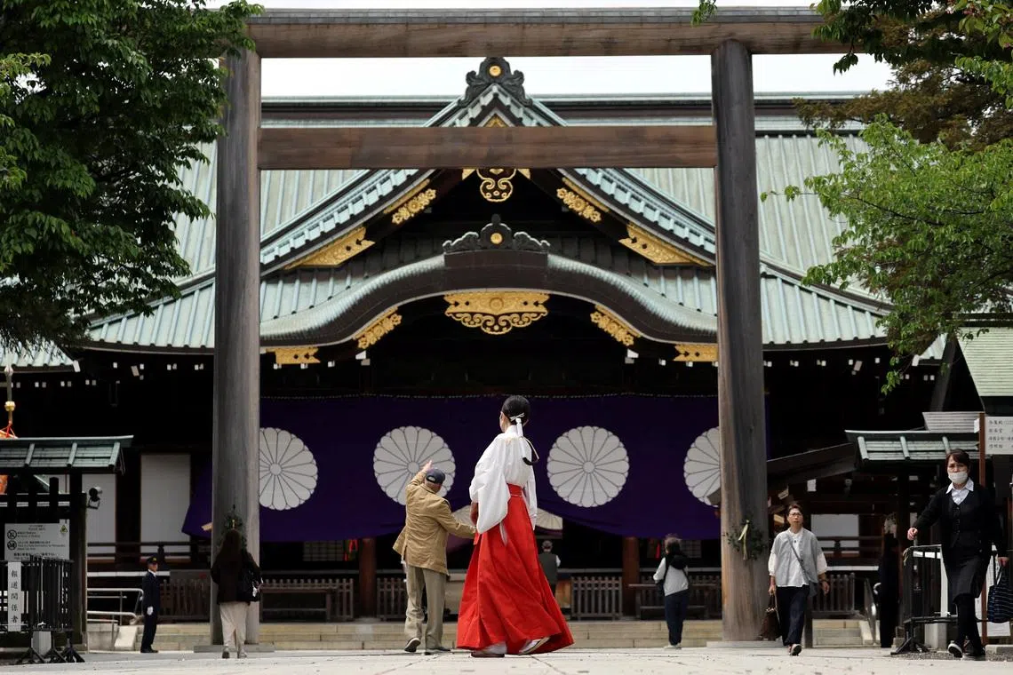 A shrine maiden walks at Yasukuni Shrine during the shrine's spring festival in Tokyo on April 21.