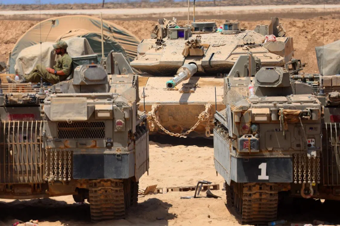 TOPSHOT - Israeli military vehicles are positioned along the border with the Gaza Strip on August 21, 2025. Israel hammered Gaza City and its outskirts overnight, residents said on August 20, as the military announced it had taken initial steps in its push to capture Hamas's last major stronghold. (Photo by Jack GUEZ / AFP)
