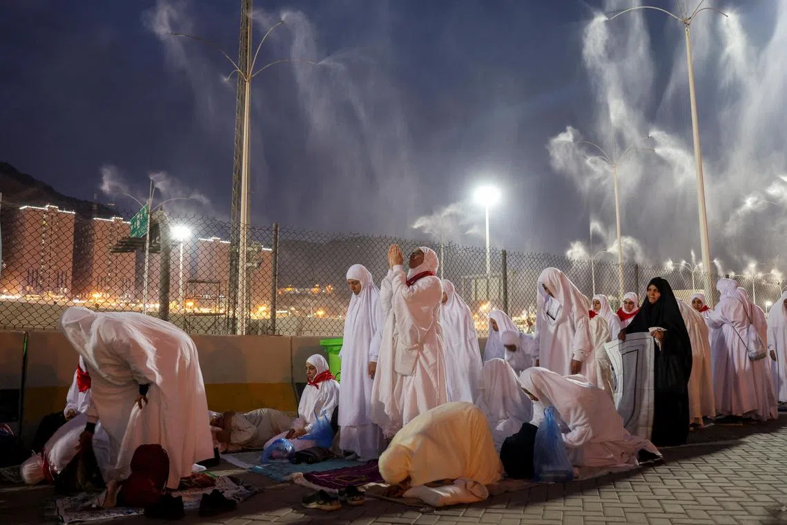 Muslim pilgrims pray as sprinklers spray water to cool them down amid extremely hot weather, during the annual haj pilgrimage, in Mina, Saudi Arabia, June 16, 2024. REUTERS/Saleh Salem


