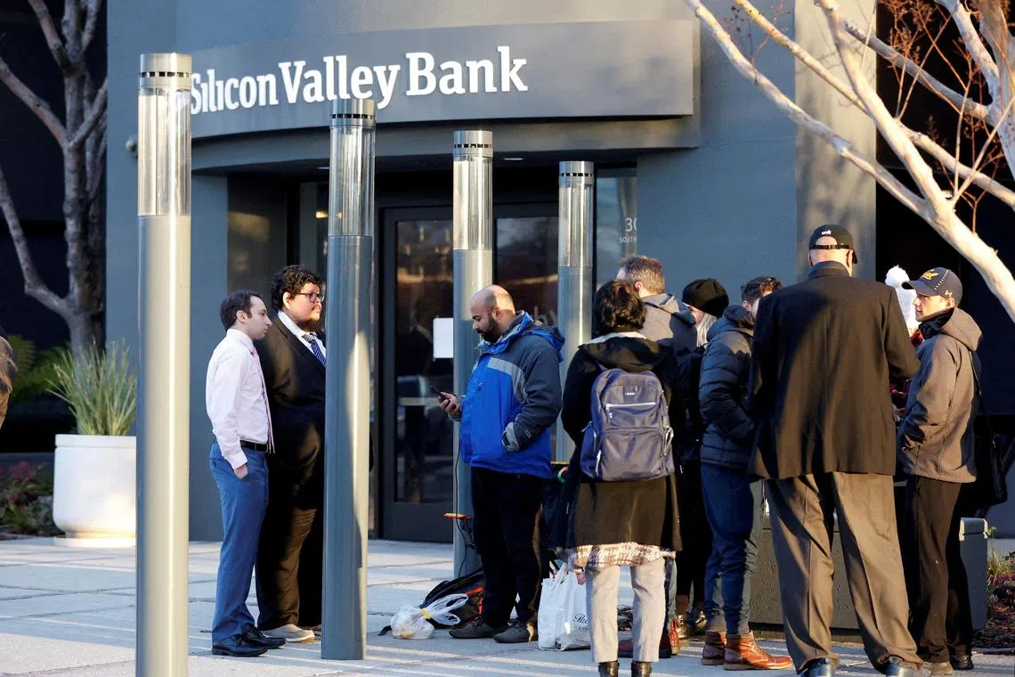 Deposit insurance officials talk to customers outside the headquarters of Silicon Valley Bank in March 2023.
