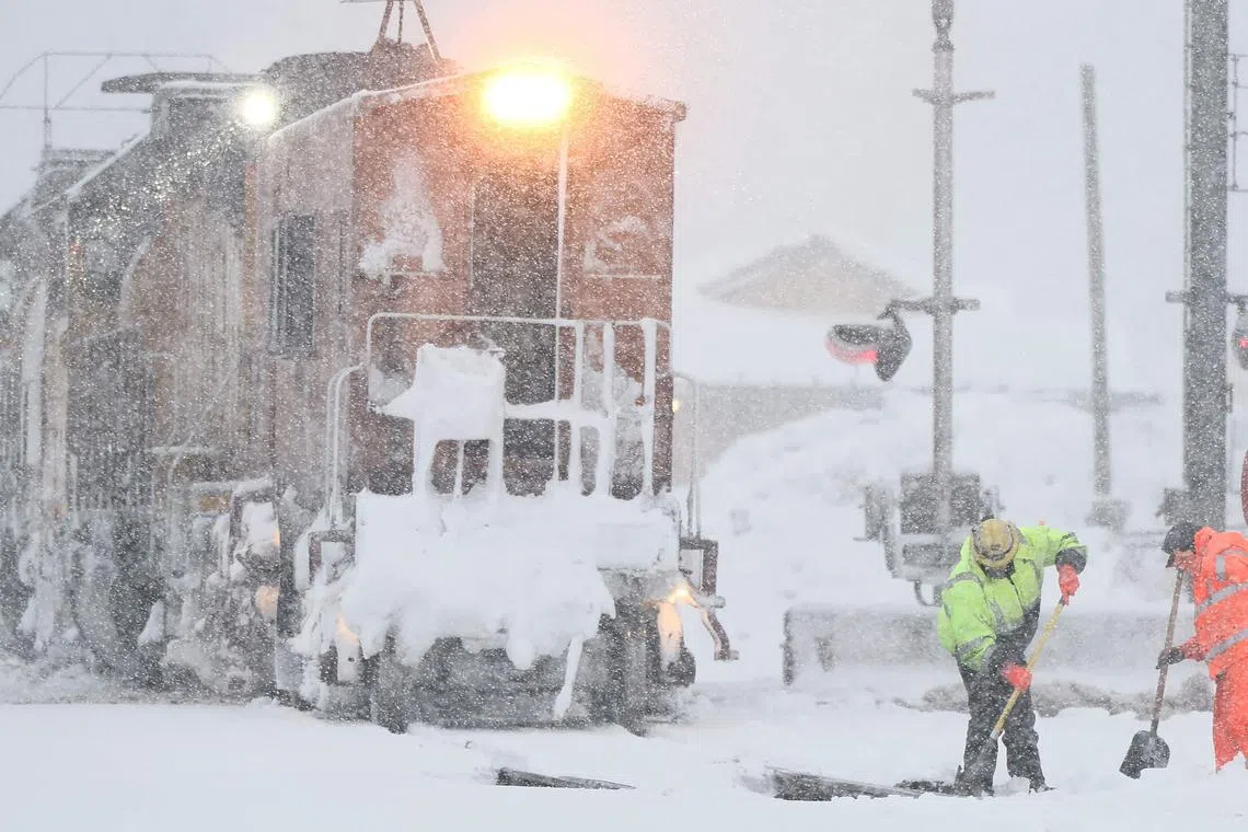 TRUCKEE, CALIFORNIA - MARCH 01: Workers clear train tracks as snow falls north of Lake Tahoe in the Sierra Nevada mountains during a powerful winter storm on March 01, 2024 in Truckee, California. Blizzard warnings have been issued with snowfall of up to 12 feet and wind gusts over 100 mph expected in some higher elevation locations.   Mario Tama/Getty Images/AFP (Photo by MARIO TAMA / GETTY IMAGES NORTH AMERICA / Getty Images via AFP)