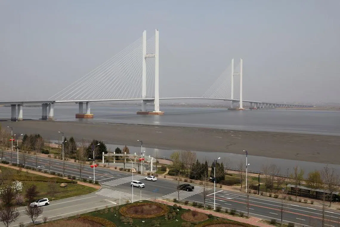 Cars travel past the New Yalu River Bridge designed to connect China's Dandong New Zone and North Korea's Sinuiju, in Dandong, Liaoning province, China April 20, 2021. Picture taken April 20, 2021.  REUTERS/Tingshu Wang