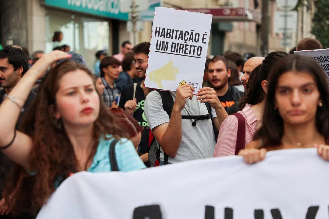 FILE PHOTO: A person holds a poster saying \"House is a right\", during a demonstration against the housing crisis in Lisbon, Portugal, September 28, 2024. REUTERS/Miguel Pereira/File Photo