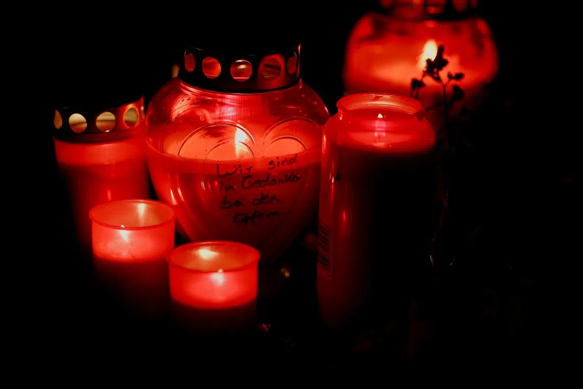 Candles, one of them with the message \"Our thoughts are with you\", sit at a makeshift memorial at the scene where a 24-year-old Afghan asylum seeker drove a car into a crowd, in what the Bavarian Premier Markus Soeder said was probably an attack, in Munich, Germany, February 13, 2025. REUTERS/Wolfgang Rattay