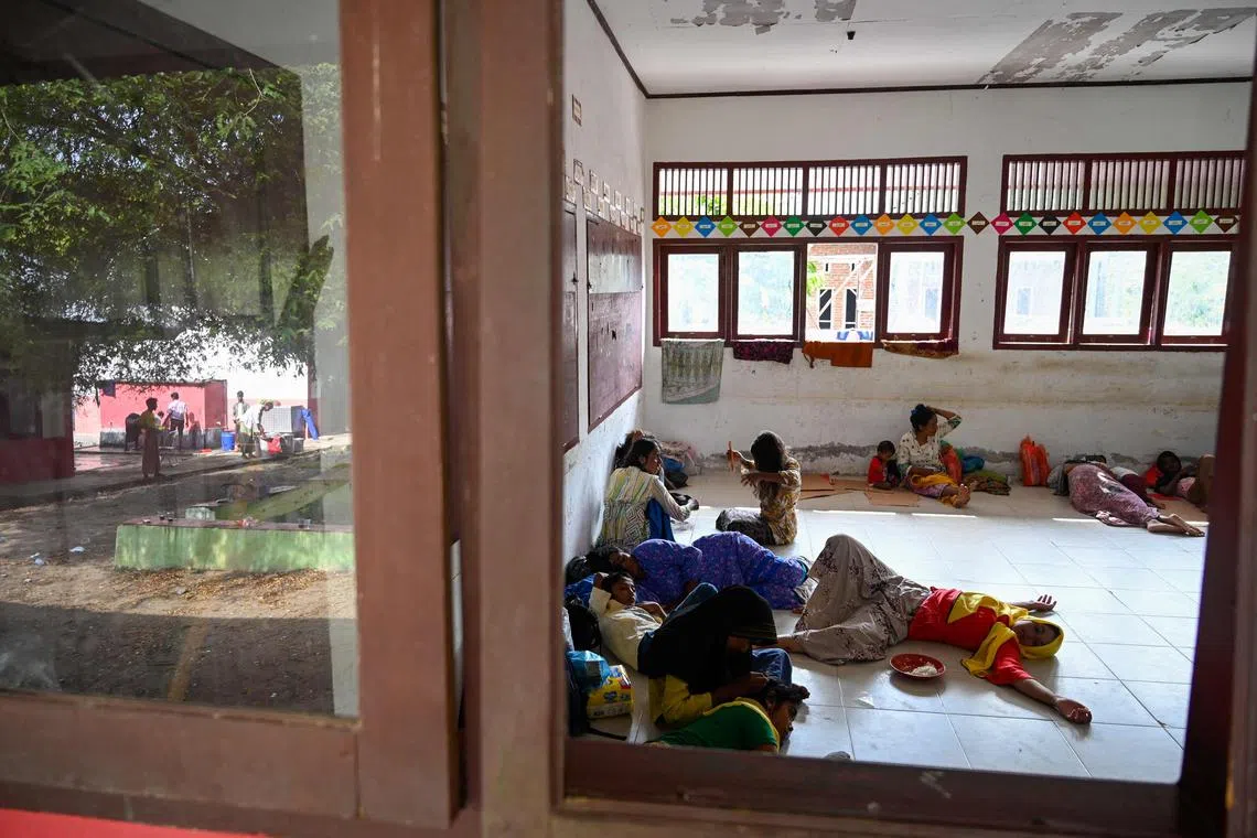 Rohingya refugees rest after being transferred to a temporary shelter following their arrival by a boat in Laweung, Aceh province on December 27, 2022. 