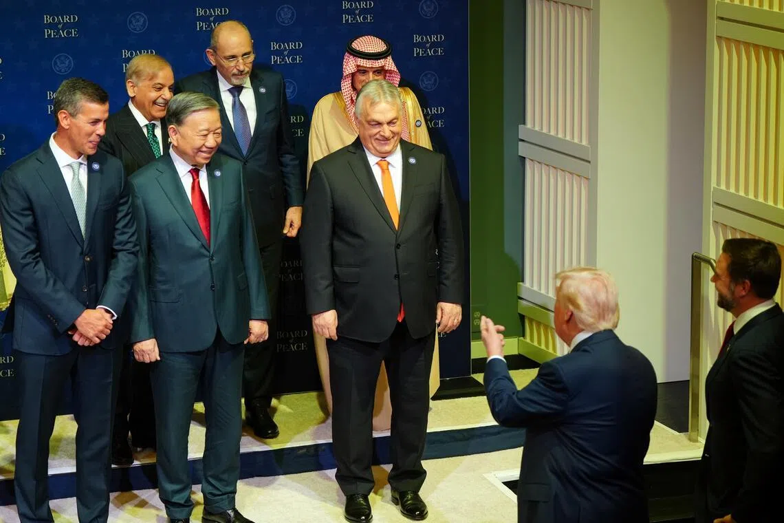 US President Donald Trump (second from right in the foreground), greeting Hungarian Prime Minister Viktor Orban (right in the front row) and Vietnamese leader To Lam (second from right in the front row) as they gather for a group portrait session ahead of the inaugural meeting of his Board of Peace in Washington on Feb 19, 2026. 